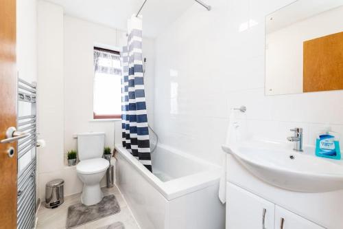 GoodmayesCosy 2 bedroom house! Dagenham! Free parking的白色的浴室设有水槽和卫生间。