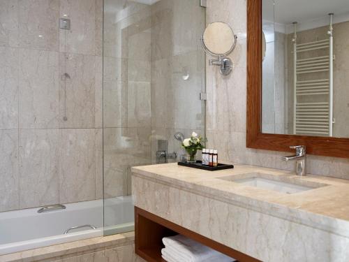约阿尼纳杜拉克会议水疗中心酒店 的一间带水槽、浴缸和镜子的浴室