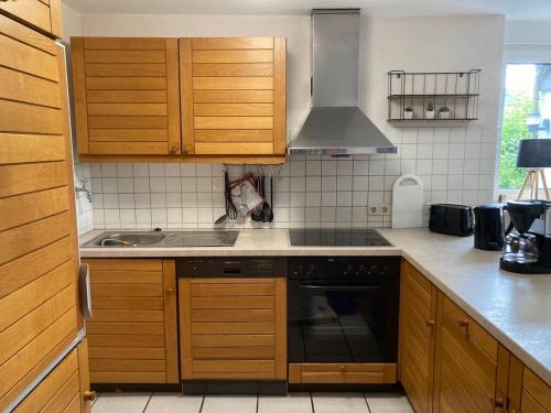 阿尔特纳SauerlandBlick的厨房配有木制橱柜和炉灶烤箱。