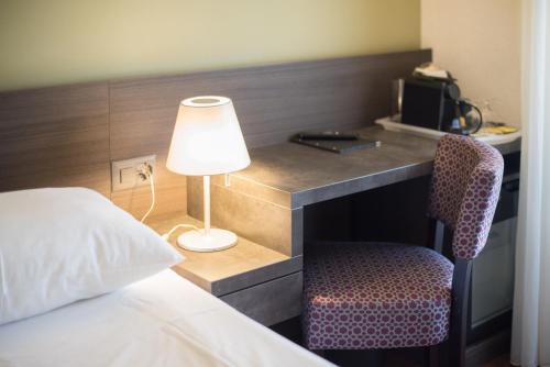 日内瓦蒙塔纳酒店的一张桌子,旁边配有一盏灯和一把椅子