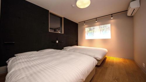 日光Rakuten STAY MOTEL Nikko Kinugawa Garage Concept Room的一间卧室设有两张床和窗户。