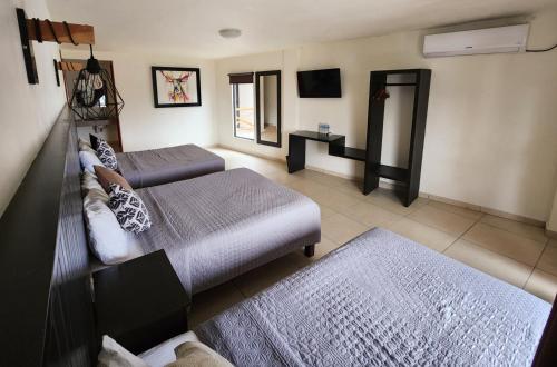 希利特拉Hotel Sierra Linda的一间带两张床和电视的客厅