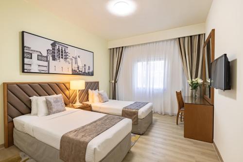 迪拜金沙公寓酒店的酒店客房设有两张床和电视。