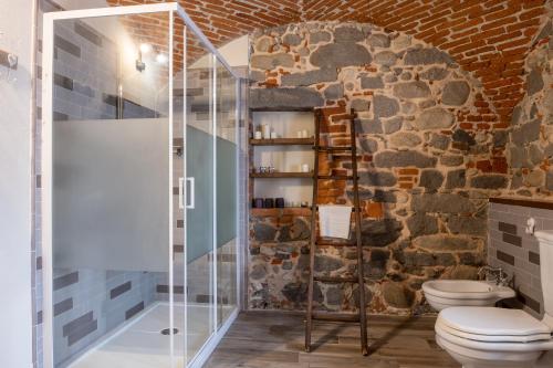 比耶拉B&b Il Cortile的石墙浴室内的玻璃淋浴间