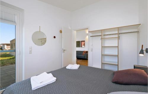 伦布鲁Stunning Home In Lembruch-dmmer See With Sauna的白色卧室设有床和滑动玻璃门