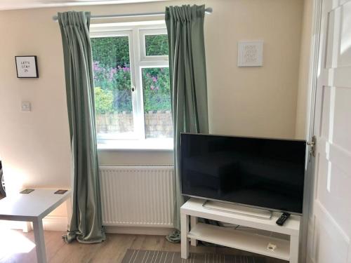 巴斯Quiet and cosy flat, close to Bath Centre的客厅配有平面电视和窗户。