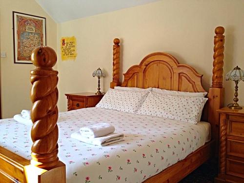 卡舍尔Cashel Town Center INN的一间卧室配有一张木床和木制床头板