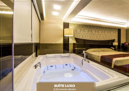 巴西利亚San Marco Hotel Brasília的带浴缸的酒店客房 - 带一张床