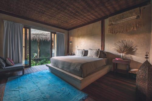 图卢姆Radhoo Tulum的一间带大床的卧室和一个阳台