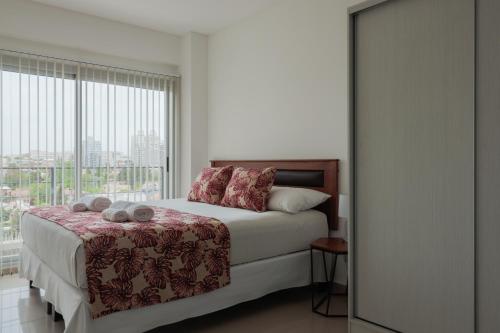 内乌肯Comfort Patagonia Inn的一间卧室设有一张床和一个大窗户