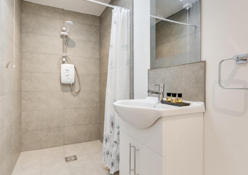 WaldingfieldArdley Cottage Squirrel的白色的浴室设有水槽和淋浴。