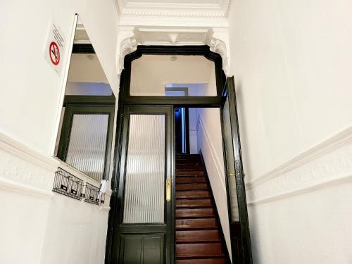 沙勒罗瓦Chambre privée au 3e étage sans ascenceur en plein centre de Charleroi的大楼内带绿门的走廊