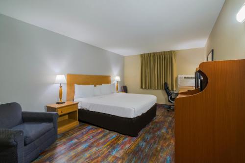 法戈Americas Best Value Inn Fargo的配有一张床和一把椅子的酒店客房