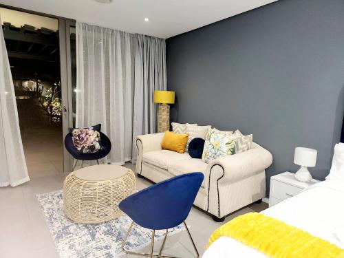 SibayaSugar Shores - Studio Apartment的客厅配有白色沙发和蓝色的墙壁