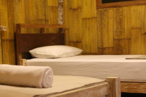 普卢坎Jungle House - surf & stay的木墙客房的两张床