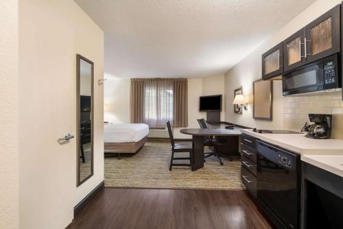 汉普顿Sonesta Simply Suites Hampton的酒店客房配有一张特大号床和一张书桌