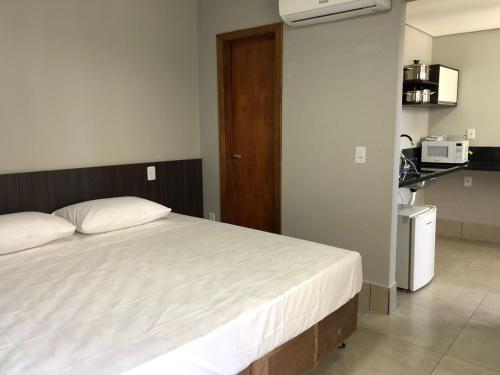 伊瓜苏Vila Nóbrega Residencial的一间带大床的卧室和一间厨房