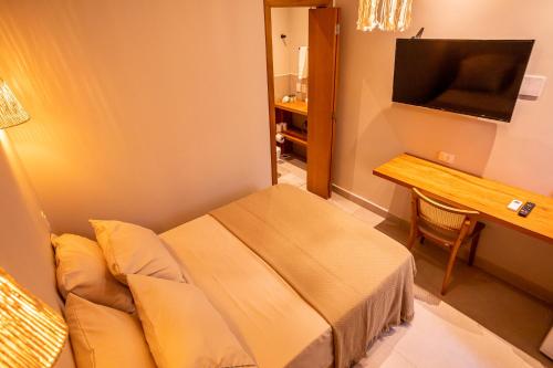 圣保罗Casa Savana的酒店客房配有一张床、一张书桌和一台电视。