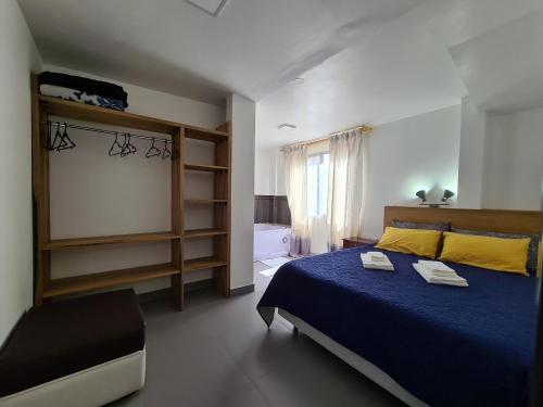 巴尼奥斯Elegante apartamento con vistas al volcán Tungurahua的一间卧室配有一张带蓝色床罩的床