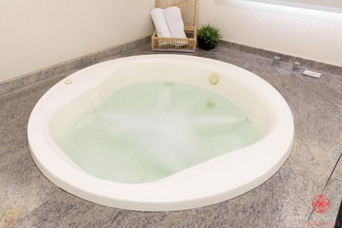弗洛里亚诺波利斯Hotel Geranius Ingleses的浴室内设有大型白色浴缸。