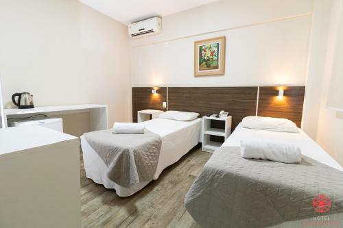 弗洛里亚诺波利斯Hotel Geranius Ingleses的酒店客房设有两张床和盥洗盆