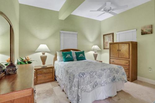 圣徒皮特海滩Palms of Treasure Island 208的一间卧室配有一张床、梳妆台和两盏灯。