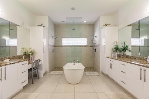 珊瑚角Villa Aviator的白色的浴室设有浴缸和水槽。