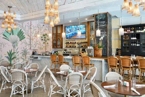 迈阿密海滩博兰南滩酒店的一间带桌椅的餐厅和一间酒吧