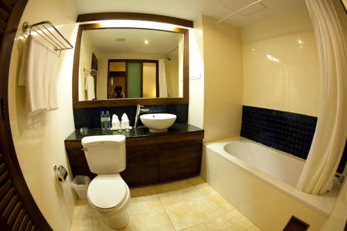 拉迈椰子海滩度假村的浴室配有卫生间、盥洗盆和浴缸。