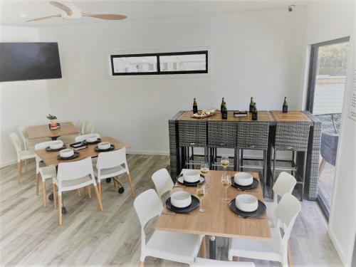 穆尔瓦拉Mulwala Resort的用餐室配有木桌和白色椅子