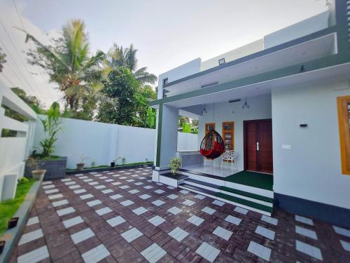 瓦亚纳德Milaano Orchids, Service Villa, Kammana Mananthavady的一座带白色墙壁的庭院的房子