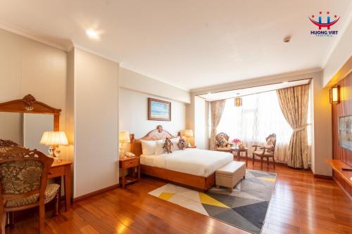 归仁Huong Viet Hotel Quy Nhon - Beachfront的一间酒店客房,一间设有一张床和一张书桌