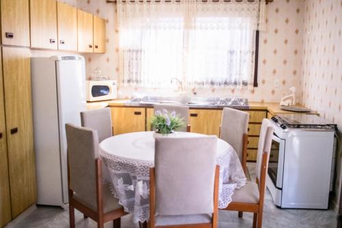 本图贡萨尔维斯Casa Di Mattoni的厨房配有桌椅和冰箱。