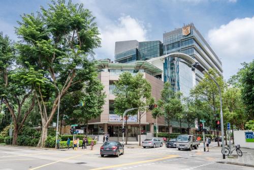 新加坡Tai Hoe Hotel的一条繁忙的城市街道,汽车停在大楼前