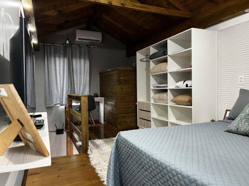 弗洛里亚诺波利斯Moradas Desterro, próximo ao aeroporto 23的一间卧室设有一张床和木制天花板