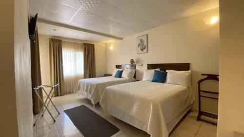 圣佩德罗苏拉Real Guanacaste的酒店客房设有两张床和窗户。
