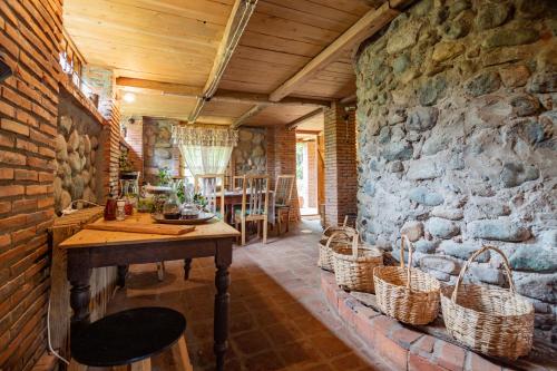 OzurgetʼiMenabde Winery的一间设有石墙、桌子和篮子的房间