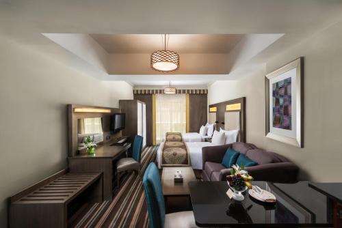 迪拜萨窝儿中央酒店公寓的带沙发的客厅和1间房间