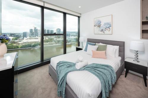 布里斯班1404 Sophistication and Luxury on the Brisbane River by Stylish Stays的一间卧室设有一张大床和大窗户