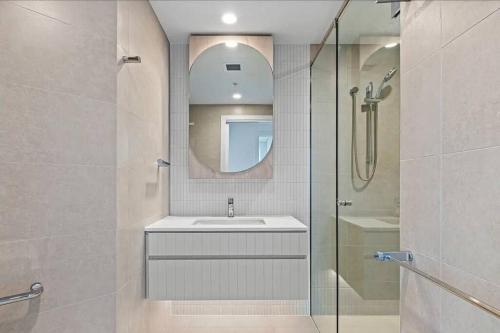 布里斯班1404 Sophistication and Luxury on the Brisbane River by Stylish Stays的浴室配有盥洗盆和带镜子的淋浴