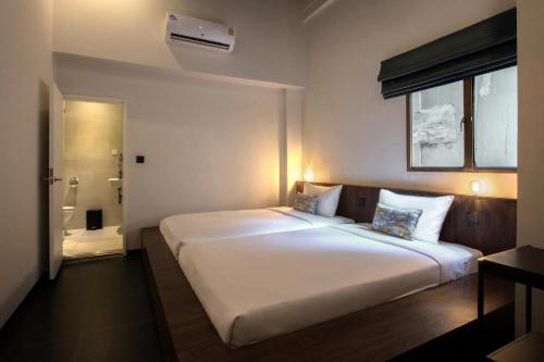曼谷Beanstalk Bangkok的配有浴室的客房内一张大白色的床