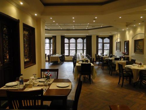 巴格达Shanasheel Palace Hotel的餐厅内带桌椅的用餐室
