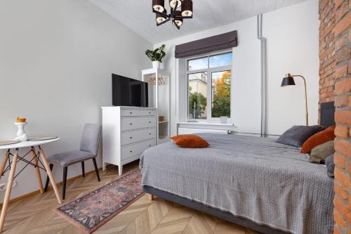 塔尔图Peetri Apartments的一间卧室配有一张床、一张桌子和一个窗户。
