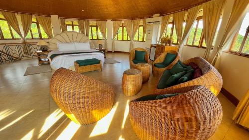 锡基霍尔锡基霍尔岛可可林海滩度假村的一间卧室配有床和藤椅