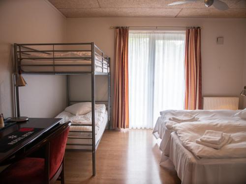 布勒鲁普索伽登布鲁普酒店的一间卧室配有两张双层床和一张书桌