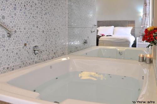 Afik伊特那塔基布兹艾菲克乡村民宿的卧室浴室设有白色浴缸