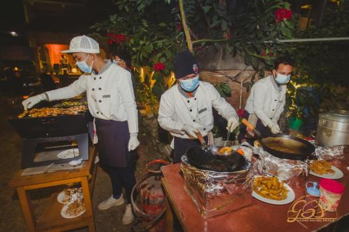 帕坦Yalamul Garden的一组三名厨师在餐桌上准备食物