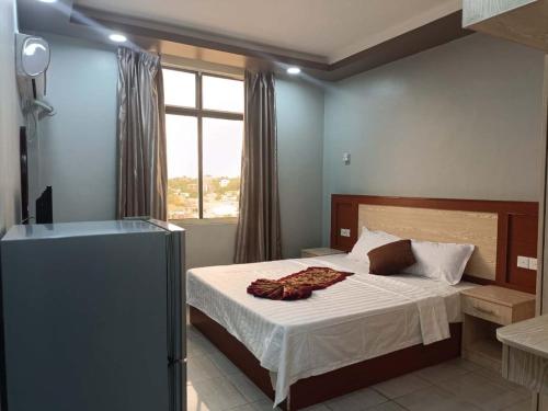 朱巴EASTERN PLAZA HOTEL的一间卧室配有一张带白色床单的床和一扇窗户。