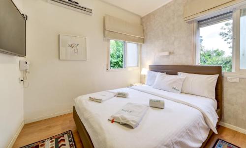 纳哈里亚SOKOLOV Vacation Boutique Apartments by the sea in nahariya的卧室配有一张白色大床和两条毛巾