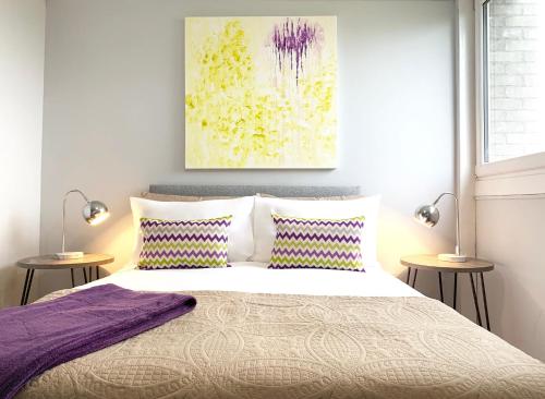 东基尔布赖德Pentland House - Lovely 2 bed flat in East Kilbride的一间卧室配有一张带两盏灯和一幅画的床铺